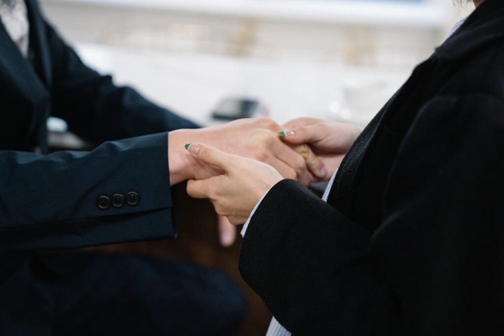 Close-up of two individuals in suits shaking hands, symbolizing business cooperation.