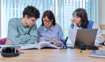college-students-with-teacher-sitting-at-desk-in-classroom-studying-languages-sciences.jpg